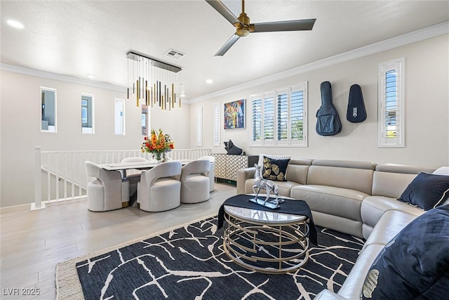 living area with ornamental molding, wood finished floors, ceiling fan, recessed lighting, and baseboards