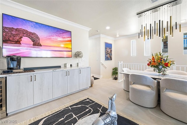 living area featuring ornamental molding, wood finished floors, recessed lighting, beverage cooler, and bar area