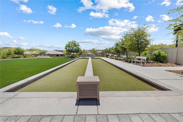 view of property's community with a game area and a lawn