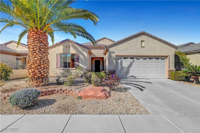 view of front facade with stucco siding, an attached garage, driveway, and a tiled roof