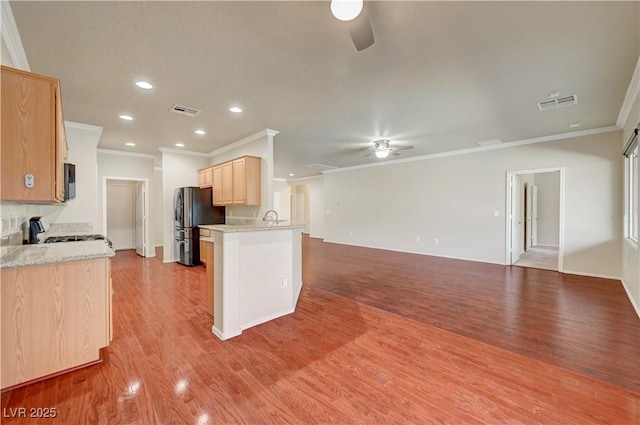 kitchen featuring a ceiling fan, freestanding refrigerator, ornamental molding, open floor plan, and light brown cabinets