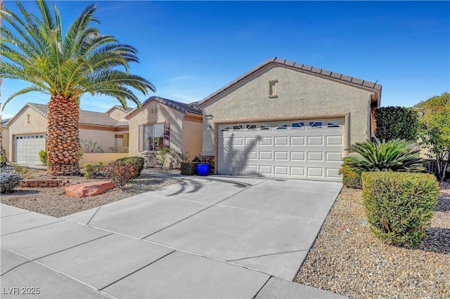 view of front of property featuring stucco siding, driveway, and an attached garage