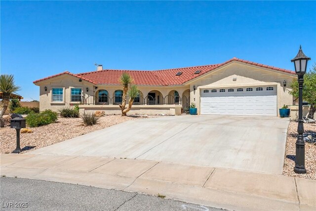 3640 E Vineyard Dr, Pahrump, NV 89048 - mediterranean / spanish-style home featuring stucco siding, concrete driveway, a garage, and a tile roof