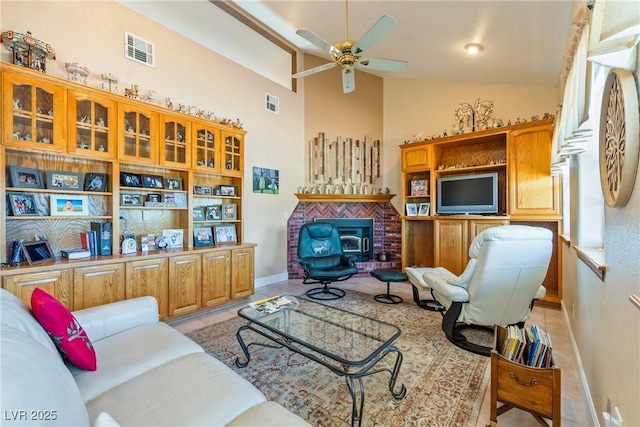 3640 E Vineyard Dr, Pahrump, NV 89048 - living area featuring a ceiling fan, a fireplace, baseboards, and high vaulted ceiling