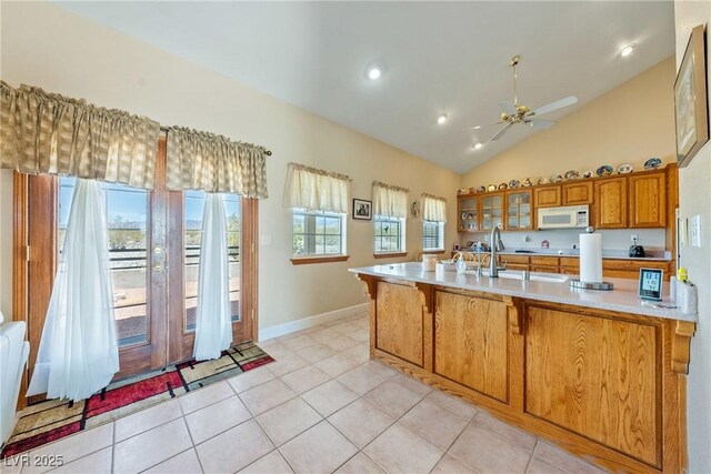 3640 E Vineyard Dr, Pahrump, NV 89048 - kitchen featuring white microwave, brown cabinetry, ceiling fan, light countertops, and lofted ceiling