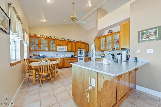 3640 E Vineyard Dr, Pahrump, NV 89048 - kitchen featuring white appliances, high vaulted ceiling, a peninsula, ceiling fan, and brown cabinetry