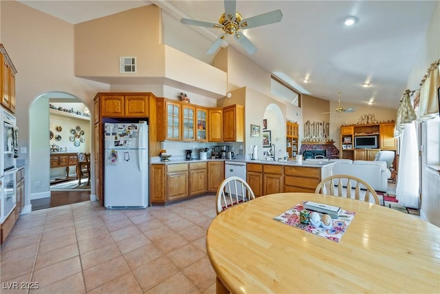 3640 E Vineyard Dr, Pahrump, NV 89048 - kitchen with white appliances, ceiling fan, arched walkways, high vaulted ceiling, and a sink