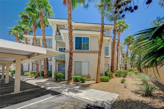 7189 S Durango Dr Unit 208, Las Vegas, NV 89113 - view of building exterior featuring covered and uncovered parking
