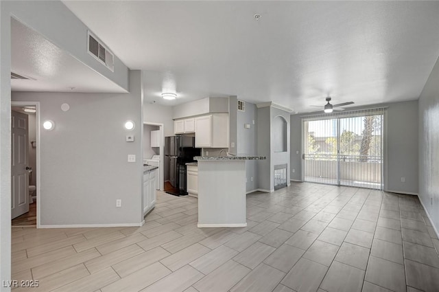 7189 S Durango Dr Unit 208, Las Vegas, NV 89113 - kitchen featuring freestanding refrigerator, open floor plan, ceiling fan, white cabinetry, and baseboards