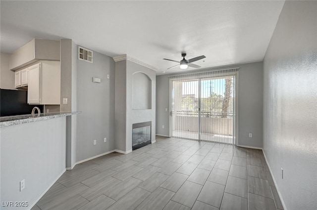 7189 S Durango Dr Unit 208, Las Vegas, NV 89113 - unfurnished living room with a ceiling fan, baseboards, a large fireplace, and wood finish floors