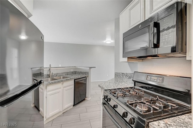 7189 S Durango Dr Unit 208, Las Vegas, NV 89113 - kitchen with black appliances, a sink, white cabinetry, and light stone countertops