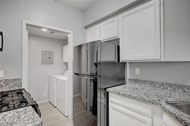 7189 S Durango Dr Unit 208, Las Vegas, NV 89113 - kitchen with separate washer and dryer, electric panel, black appliances, white cabinets, and light wood-style flooring