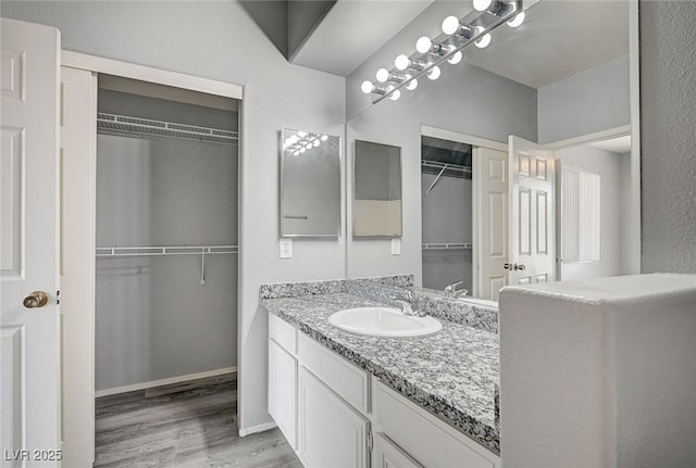7189 S Durango Dr Unit 208, Las Vegas, NV 89113 - full bath featuring vanity, wood finished floors, and a spacious closet
