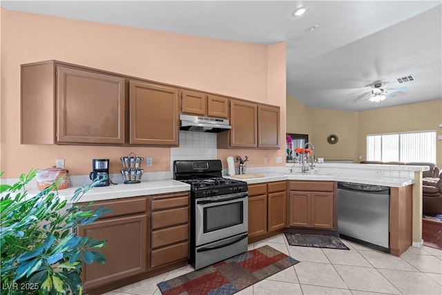 608 Blooming View Ave, North Las Vegas, NV 89032 - kitchen with appliances with stainless steel finishes, under cabinet range hood, a peninsula, a sink, and light tile patterned floors