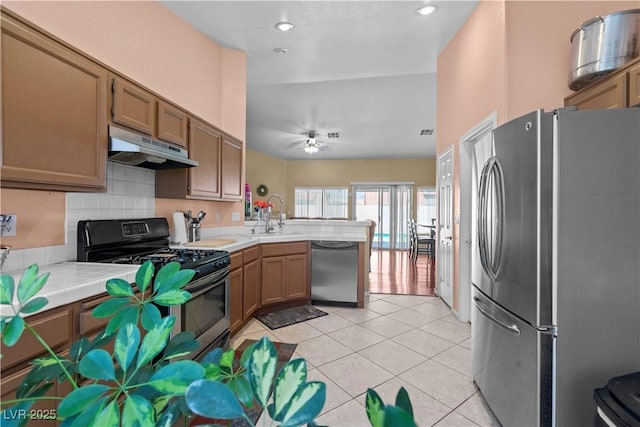 608 Blooming View Ave, North Las Vegas, NV 89032 - kitchen with stainless steel appliances, under cabinet range hood, a peninsula, tile counters, and a sink