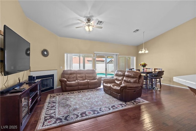 608 Blooming View Ave, North Las Vegas, NV 89032 - living area featuring a chandelier, wood finished floors, vaulted ceiling, a tile fireplace, and ceiling fan