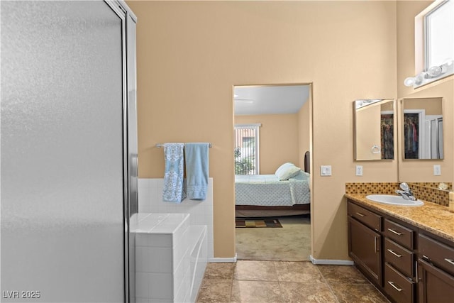 608 Blooming View Ave, North Las Vegas, NV 89032 - bathroom with vanity, a stall shower, a garden tub, tile patterned floors, and baseboards