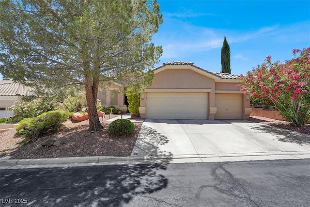 view of front of house featuring an attached garage, a tiled roof, stucco siding, and driveway