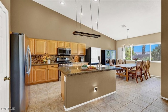kitchen featuring appliances with stainless steel finishes, high vaulted ceiling, a sink, light brown cabinets, and a center island with sink