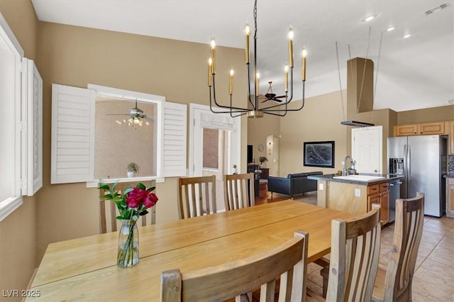 dining room featuring a chandelier, light tile patterned floors, and a ceiling fan
