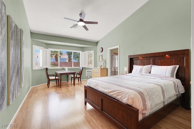bedroom with light wood-style flooring, vaulted ceiling, a ceiling fan, and baseboards