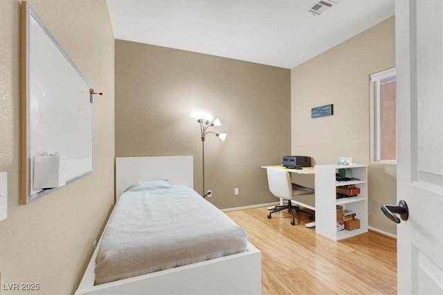bedroom featuring wood finished floors, baseboards, and a desk