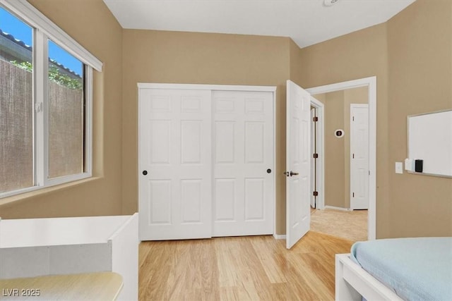 bedroom featuring light wood finished floors and a closet