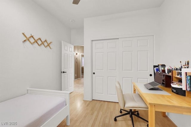 home office with light wood-style floors and a ceiling fan