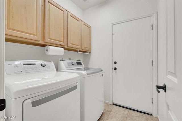laundry area featuring washer and dryer, cabinet space, and light tile patterned flooring