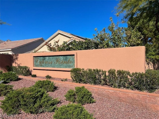 view of side of home with stucco siding and fence