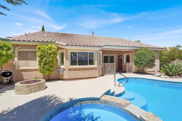 view of swimming pool with a patio area, a fire pit, and a pool with connected hot tub