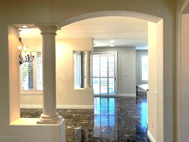 10237 Andante Ct, Las Vegas, NV 89135 - hallway with arched walkways, baseboards, decorative columns, a chandelier, and marble finish floors