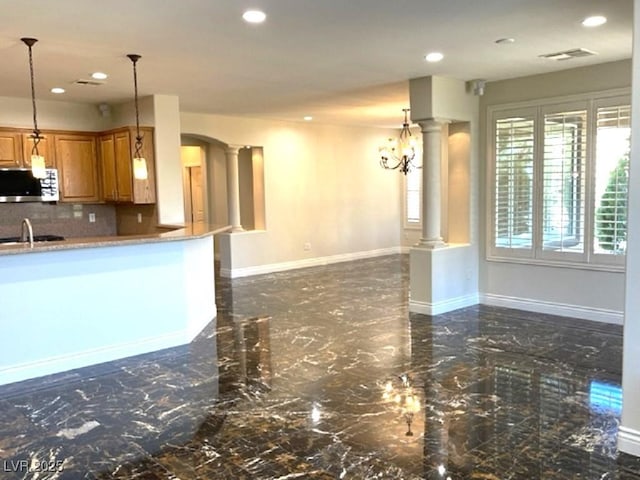 10237 Andante Ct, Las Vegas, NV 89135 - kitchen with stainless steel microwave, ornate columns, brown cabinets, recessed lighting, and backsplash