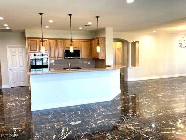 10237 Andante Ct, Las Vegas, NV 89135 - kitchen featuring stainless steel appliances, brown cabinets, recessed lighting, baseboards, and decorative backsplash