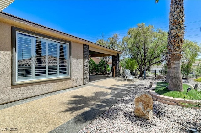 10237 Andante Ct, Las Vegas, NV 89135 - view of side of property featuring stucco siding, a patio, and fence