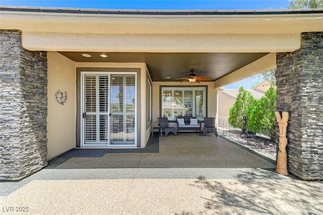 10237 Andante Ct, Las Vegas, NV 89135 - entrance to property with ceiling fan, stucco siding, a patio area, stone siding, and outdoor lounge area