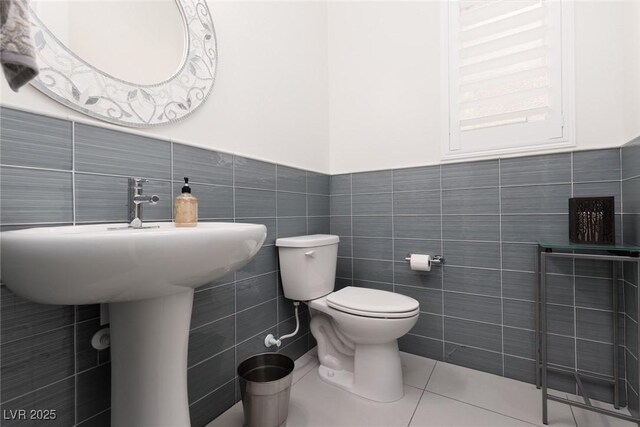 12844 New Providence St, Las Vegas, NV 89141 - half bathroom featuring tile walls, toilet, tile patterned flooring, and a wainscoted wall