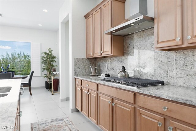 12844 New Providence St, Las Vegas, NV 89141 - kitchen featuring wall chimney range hood, stainless steel gas stovetop, light tile patterned flooring, backsplash, and light stone countertops