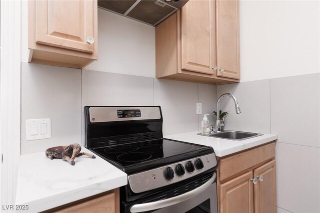 12844 New Providence St, Las Vegas, NV 89141 - kitchen with stainless steel electric stove, light brown cabinets, ventilation hood, a sink, and light countertops