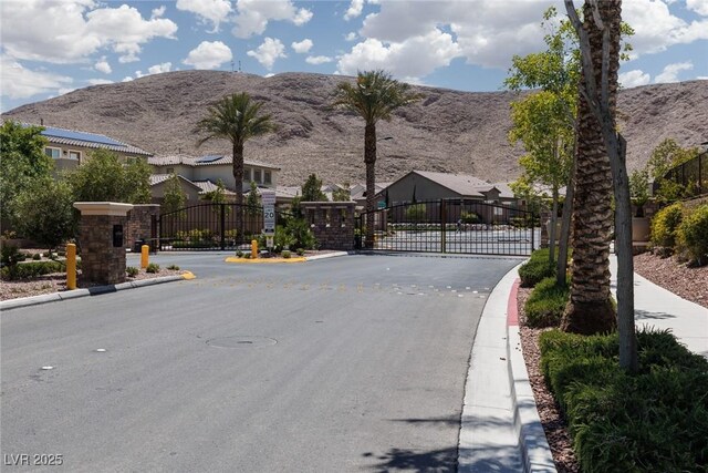 12844 New Providence St, Las Vegas, NV 89141 - view of asphalt road featuring a gate, curbs, a gated entry, and a mountain view