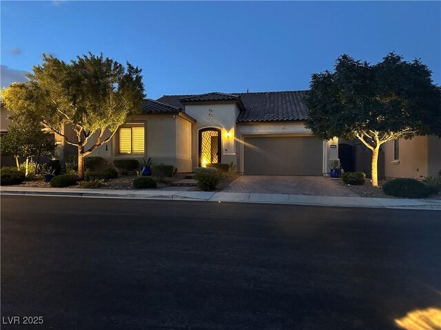 12844 New Providence St, Las Vegas, NV 89141 - mediterranean / spanish home featuring a garage, a tile roof, driveway, and stucco siding