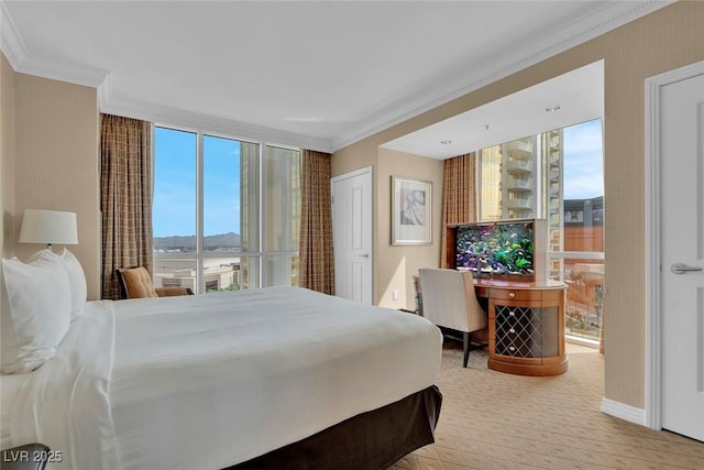 135 E Harmon Ave Unit 1102, Las Vegas, NV 89109 - bedroom with crown molding, carpet floors, baseboards, a wall of windows, and a water view
