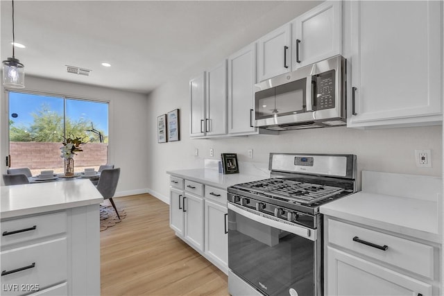 kitchen with stainless steel appliances, light wood-style flooring, light countertops, white cabinetry, and recessed lighting