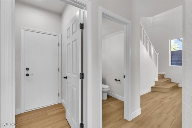 stairway featuring wood finished floors and baseboards