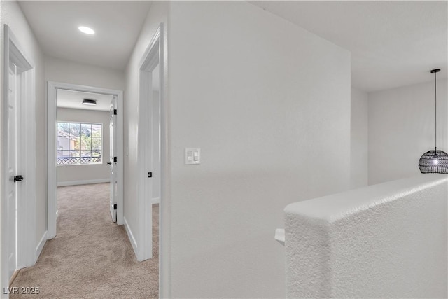 hallway with light carpet, baseboards, and recessed lighting