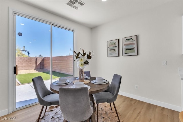 dining space with baseboards and light wood finished floors