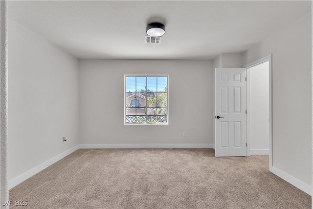 carpeted spare room featuring baseboards