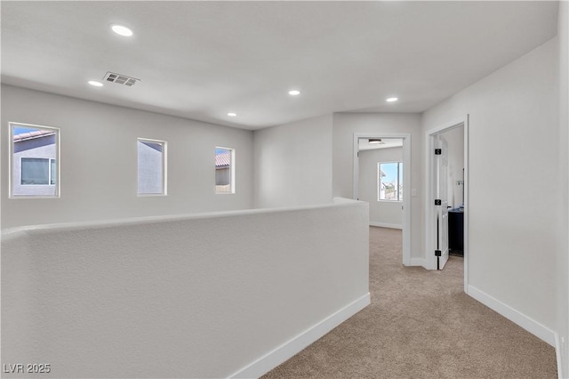 hall featuring light carpet, recessed lighting, and baseboards