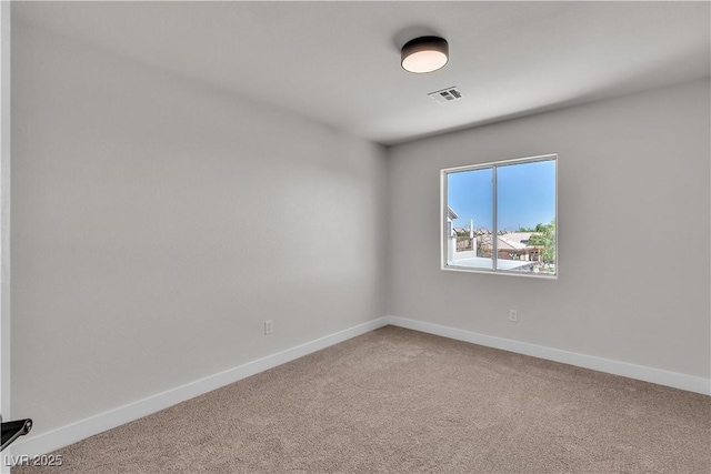 unfurnished room with carpet and baseboards