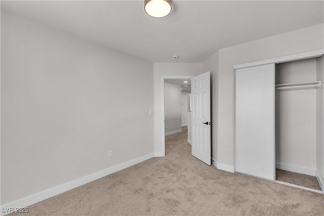 unfurnished bedroom with carpet flooring, a closet, and baseboards